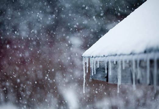 Icicles hanging off a snowy roof.