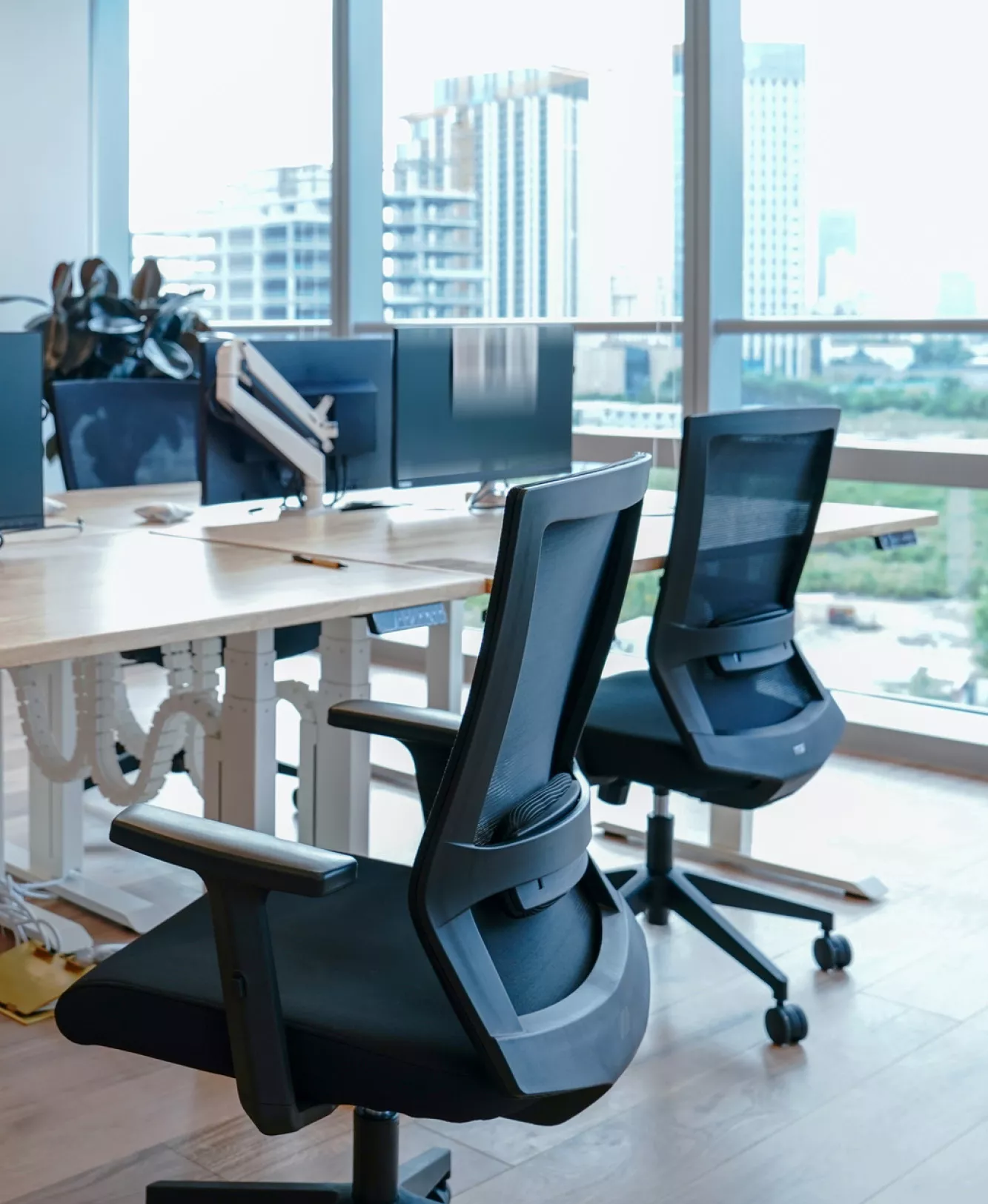 Empty office chairs around a conference table in a downtown office environment.