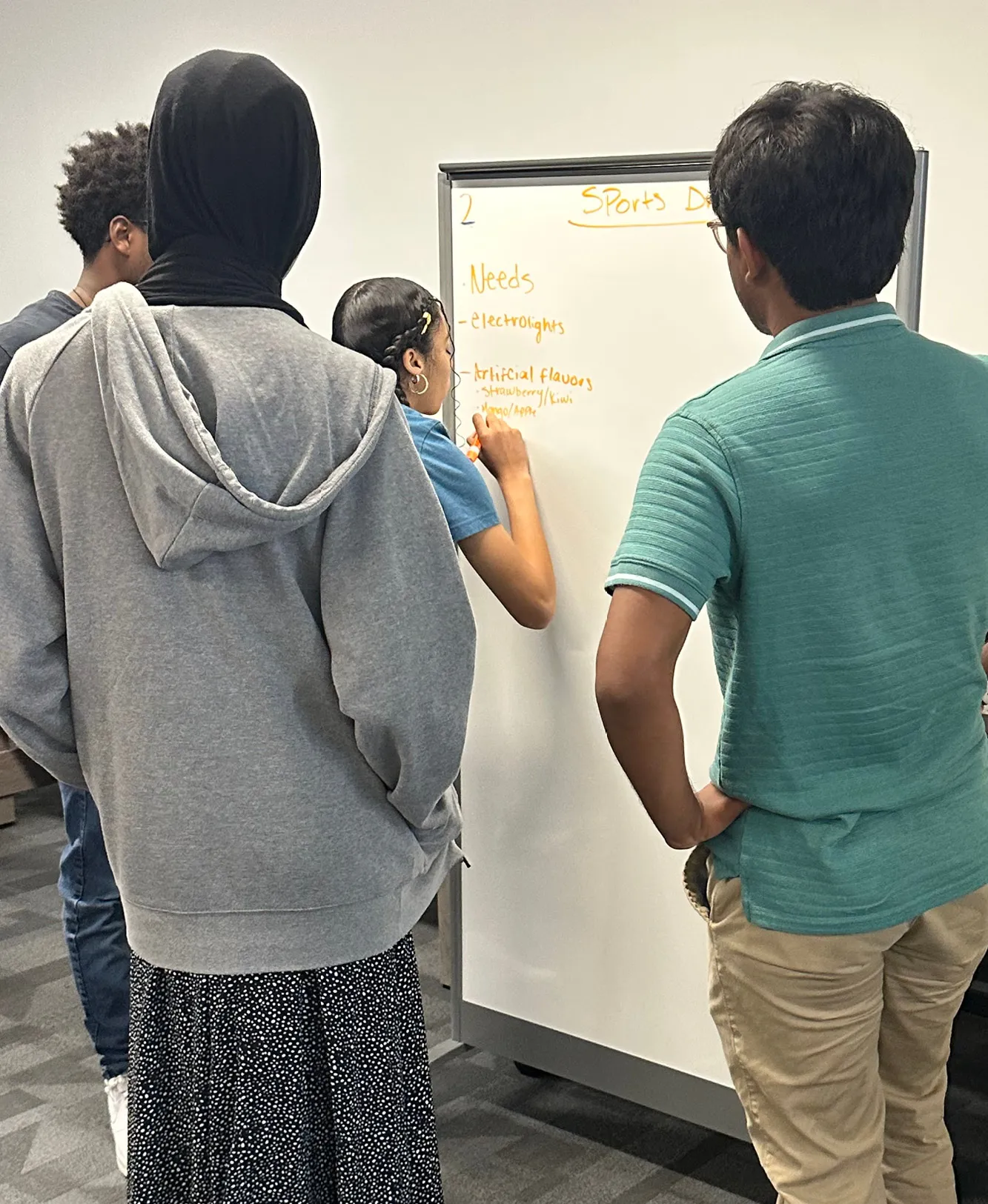 Three DiscoverYou students standing around a dry erase board.