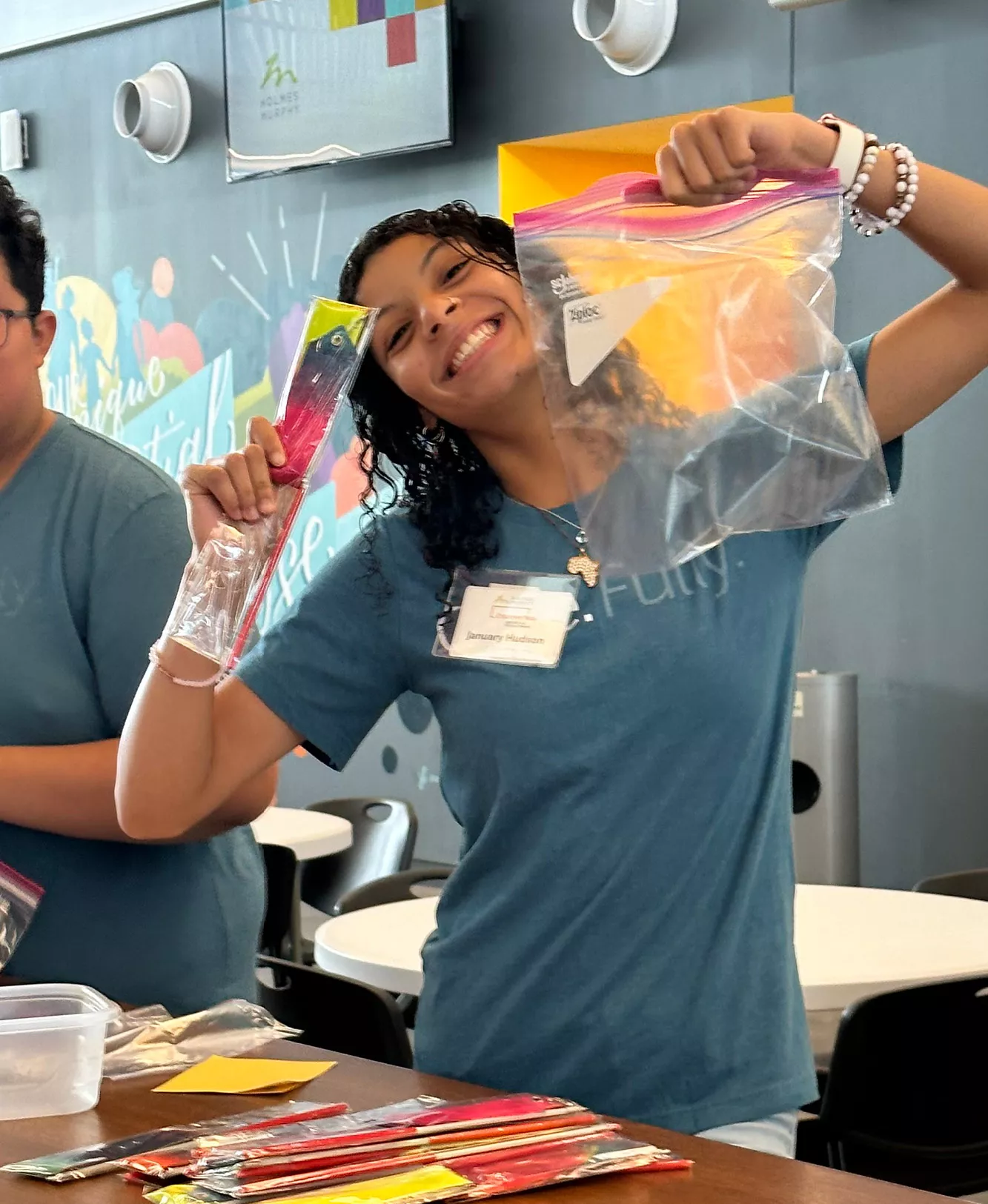 A DiscoverYou student smiling and holding up a baggie while volunteering with the program.