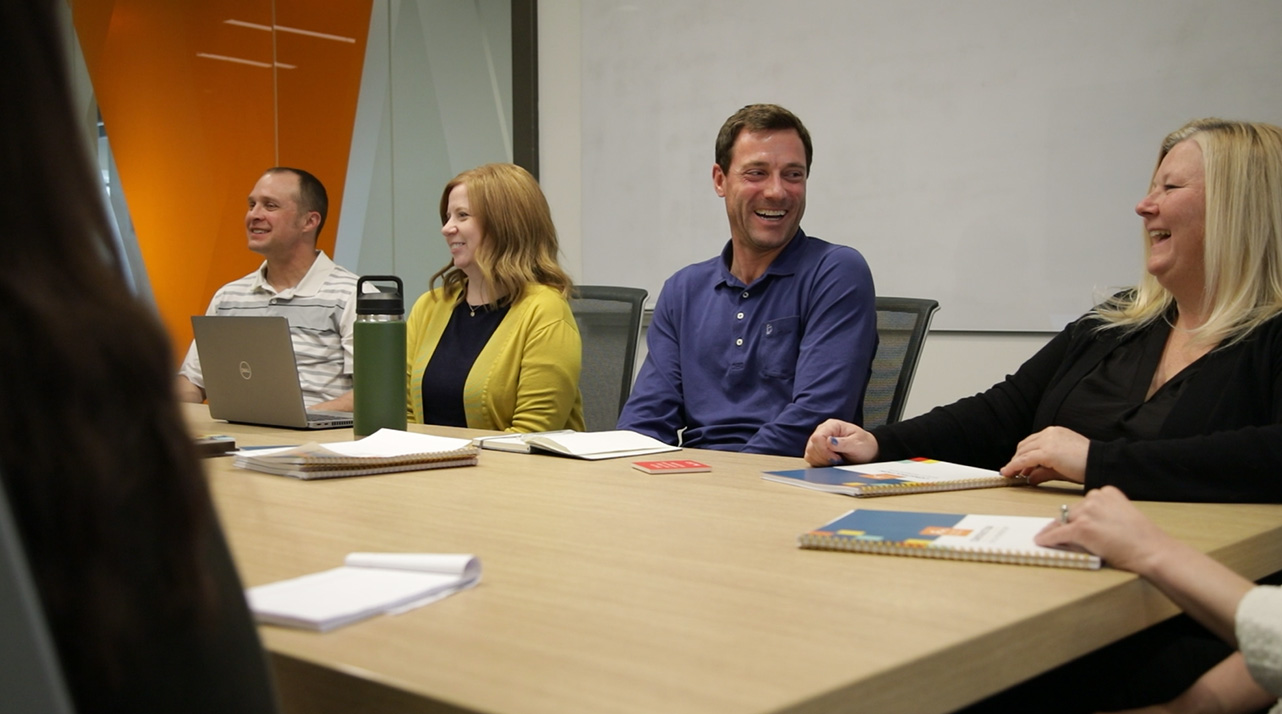 A group of Holmes Murphy employees smiling around a conference table.