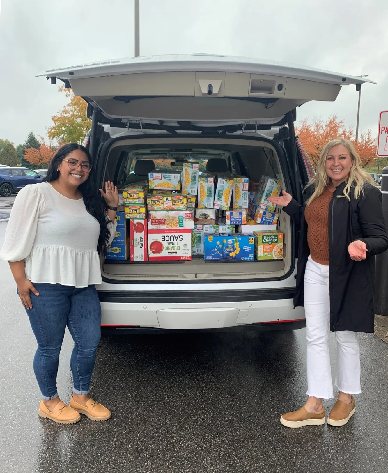 Two Holmes Murphy employees showcasing a supply drive delivery.