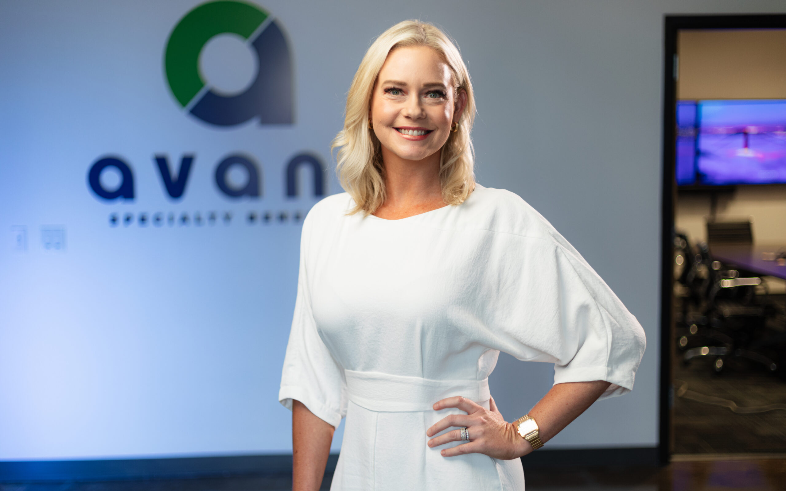 Lauren Roth in an elegant white blouse in front of an Avant backdrop.