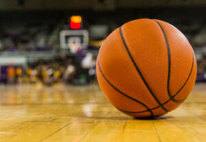A basketball on an arena basketball court floor.
