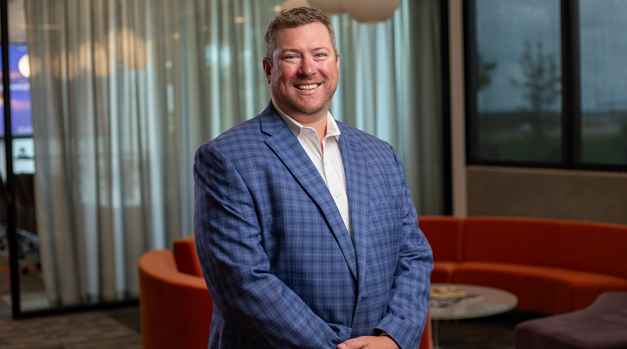 Mike Curtis in a blue striped suit smiling