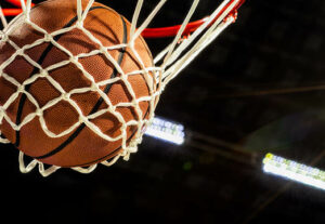 A basketball swooshing through a hoop.