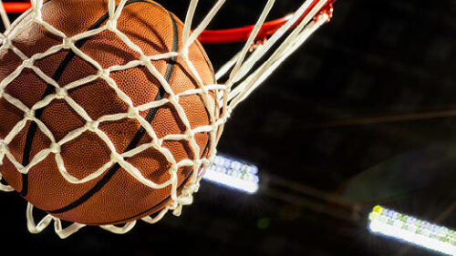 A basketball swooshing through a hoop.