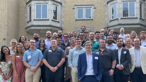 A group of Fraternal Practice Professionals in front of an academic building
