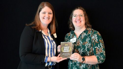 Lisa and Michelle holding an award for Holmes Murphy from the University of Iowa