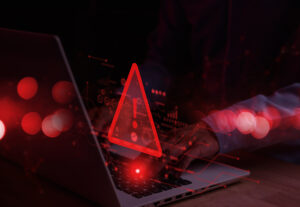 A warning symbol in red hovering above a computer.