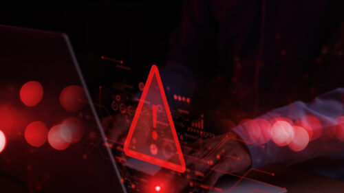 A warning symbol in red hovering above a computer.