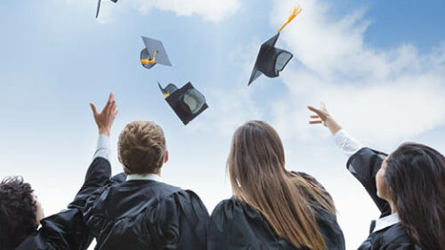 College graduates throwing their cap in the air
