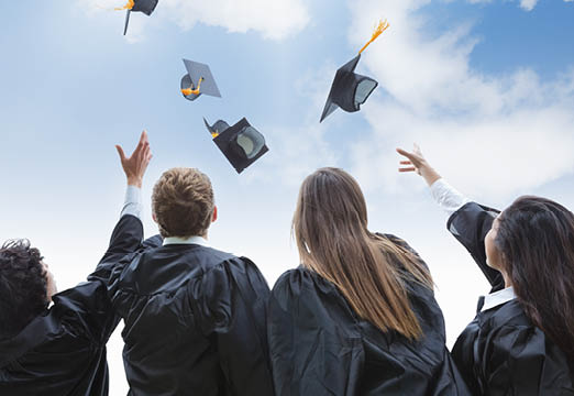 College graduates throwing their cap in the air