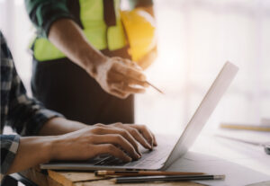 Two construction professionals discussing over a computer