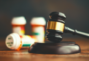 Bottles of medication and a court gavel.