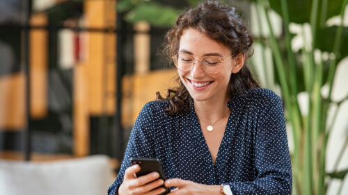 A young woman typing on her phone
