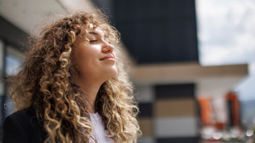 A woman enjoying the sun on her face.