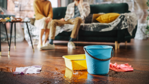 Buckets catch leaking water in a home.