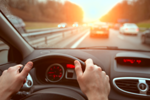 A driver holds the steering wheel in highway traffic.