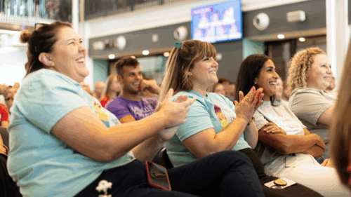 Holmes Murphy employees clap and smile during a company meeting.