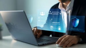 A person sits at their laptop with cyber security and data protection images