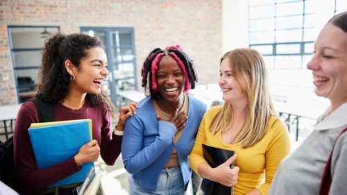 A group of students laugh at smile at a college event.