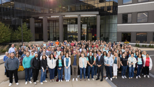 large group of Holmes Murphy employees standing in front of an office building.